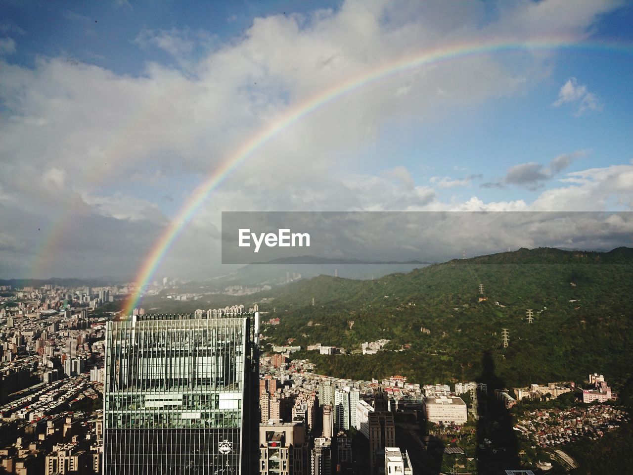 SCENIC VIEW OF RAINBOW OVER CITY BUILDINGS