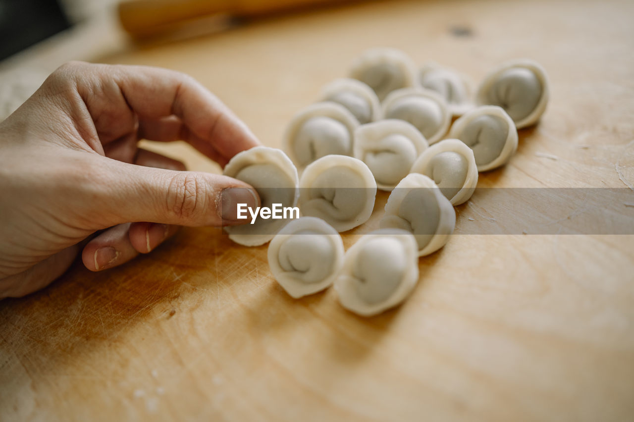 Woman arranging dumplings on cutting board