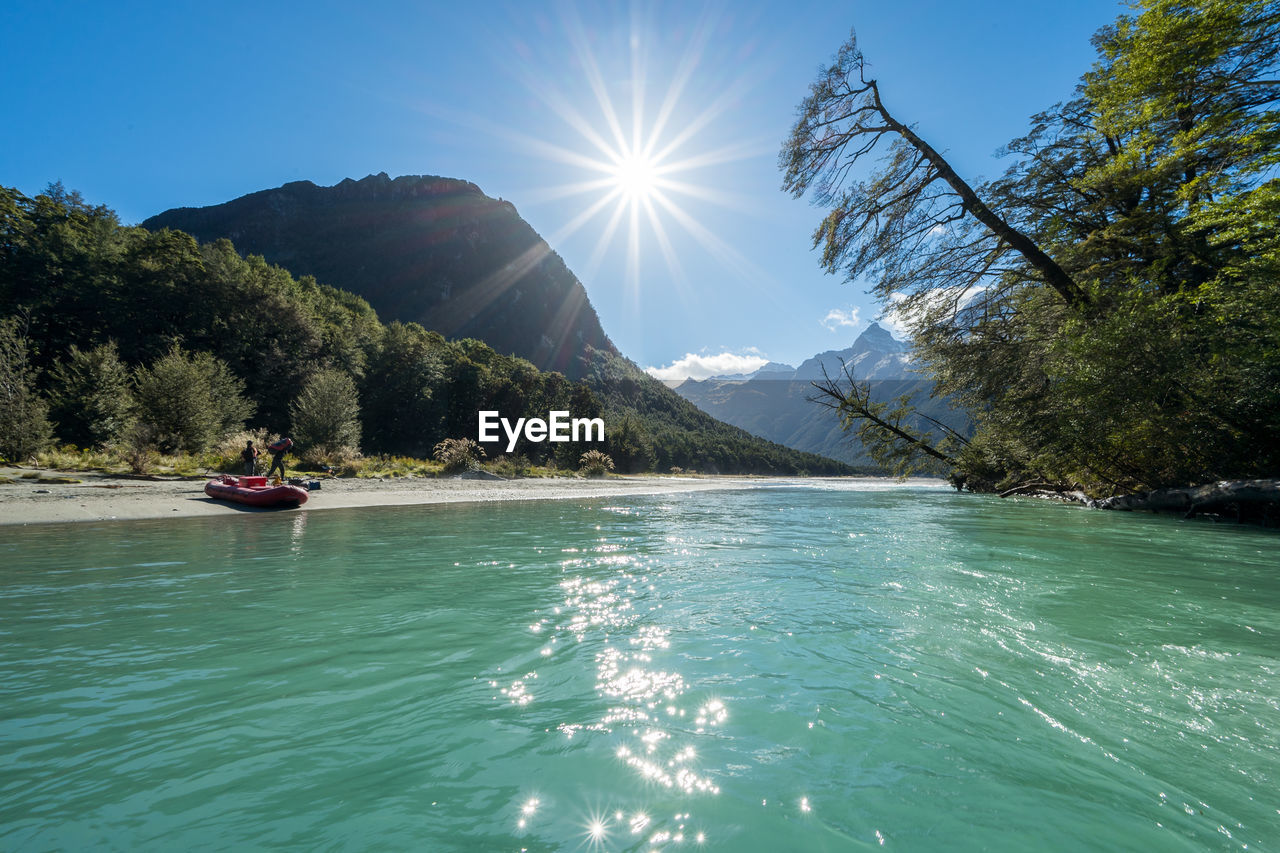 SCENIC VIEW OF LAKE AGAINST TREES AND MOUNTAIN