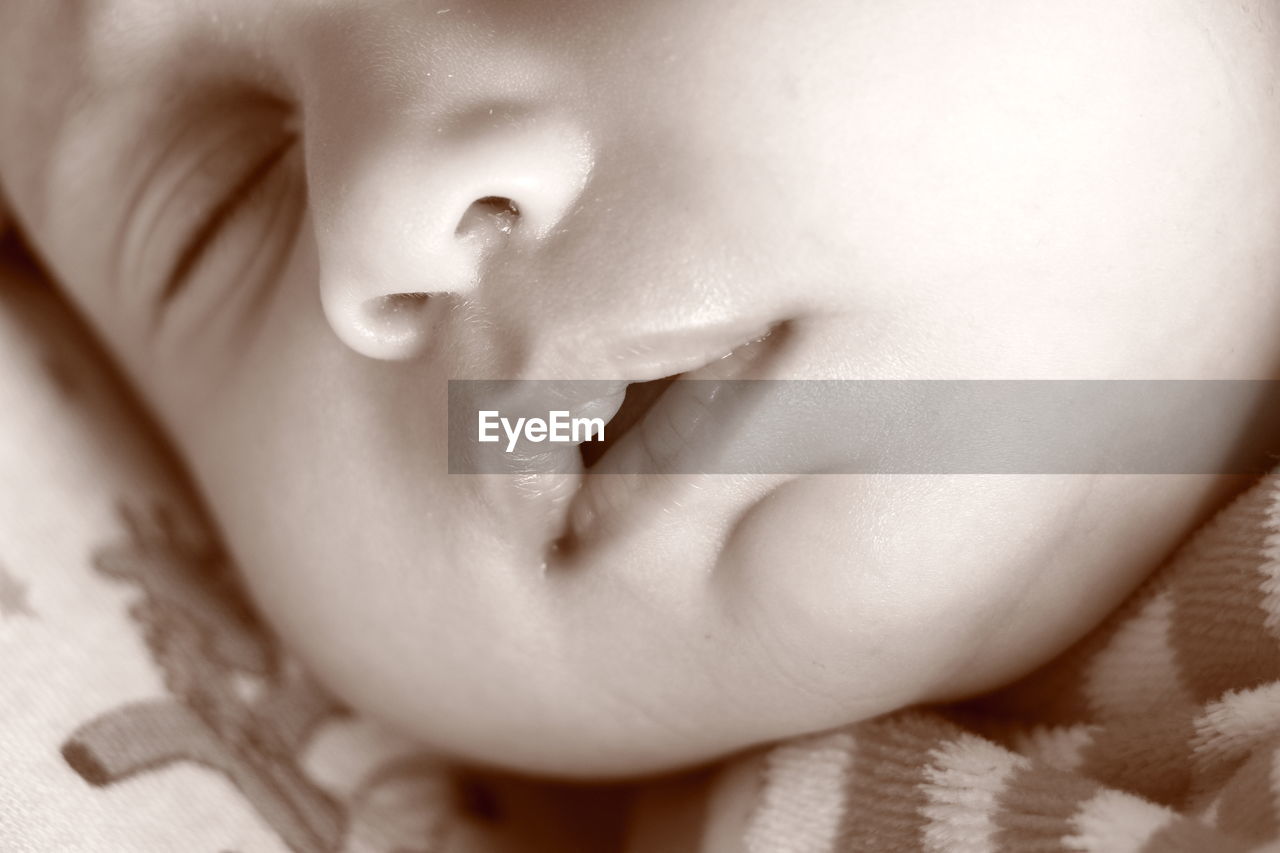 Close-up of baby girl sleeping on bed at home