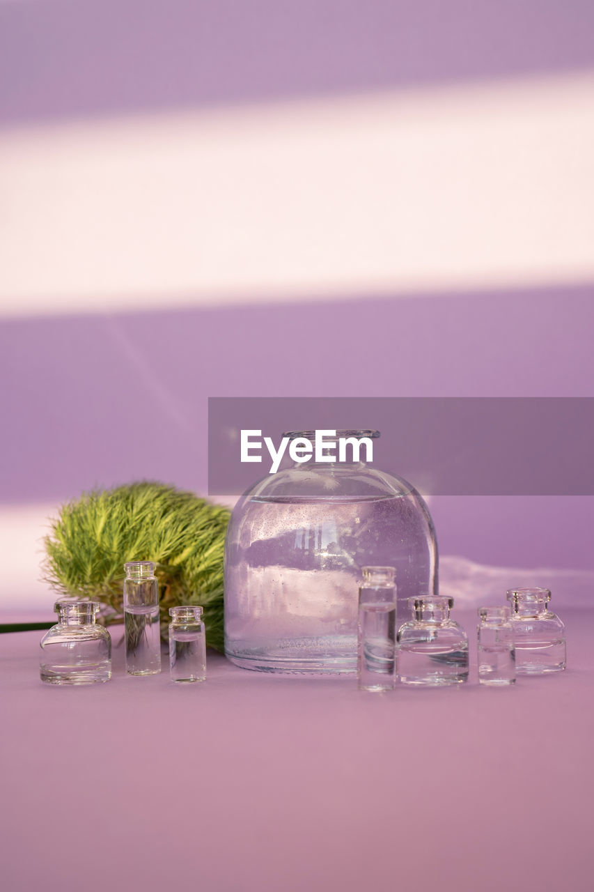 Beautiful abstract background with glass containers on a purple background.