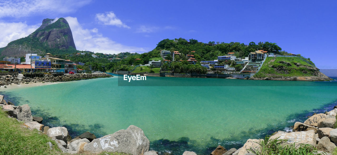 PANORAMIC SHOT OF SEA BY BUILDINGS AGAINST SKY