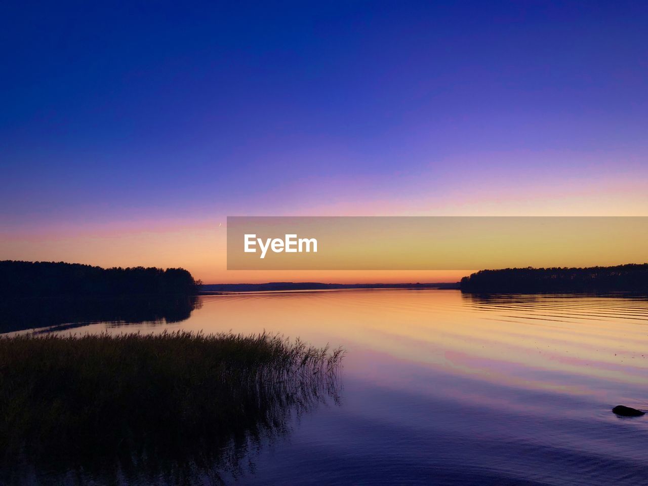 Scenic view of lake against sky during sunset