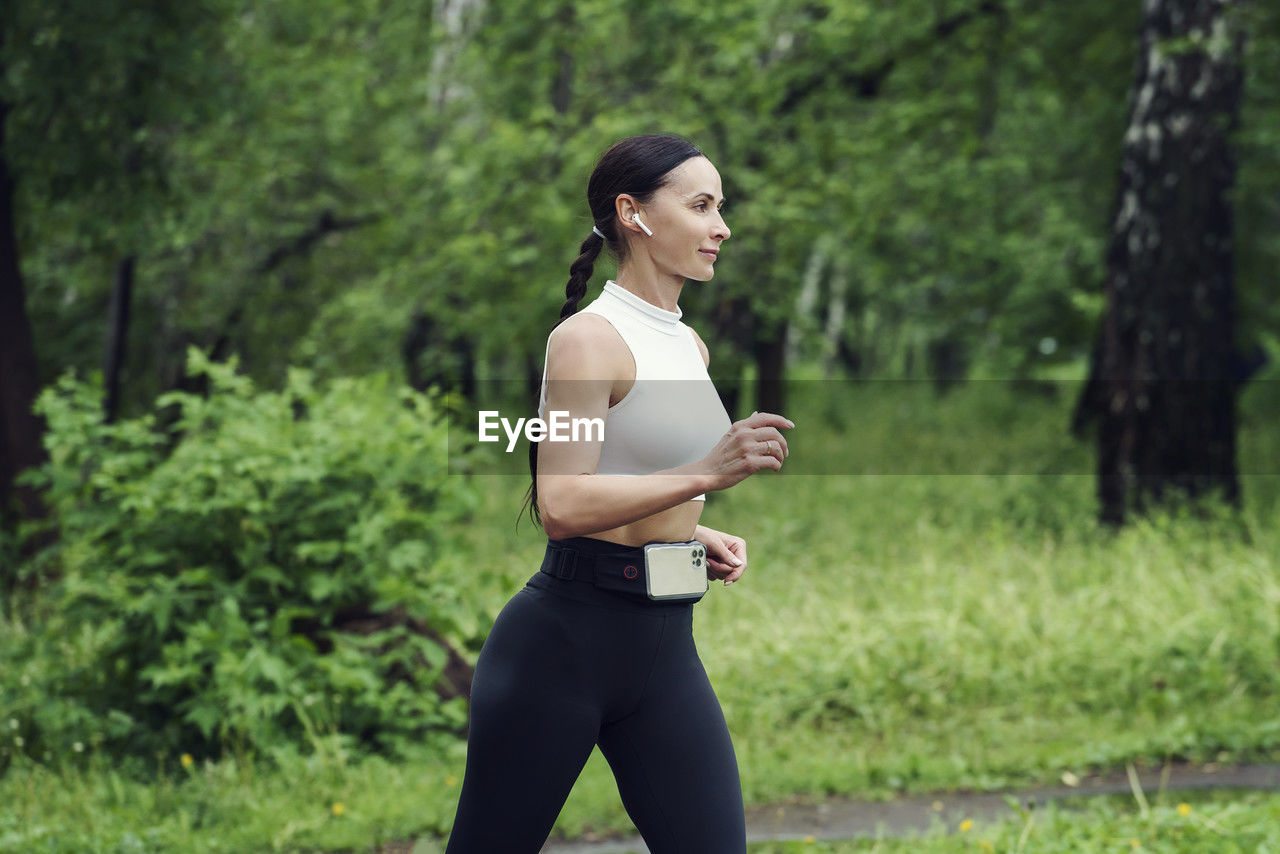 A female athlete runs in the park, does fitness, reduces weight, and leads a healthy lifestyle