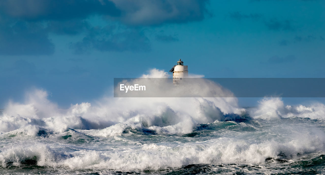 The lighthouse of the mangiabarche shrouded by the waves of a mistral wind storm
