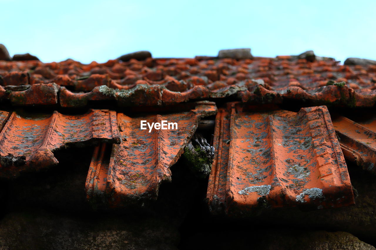 Deteriorated roof tiles covered with lichen