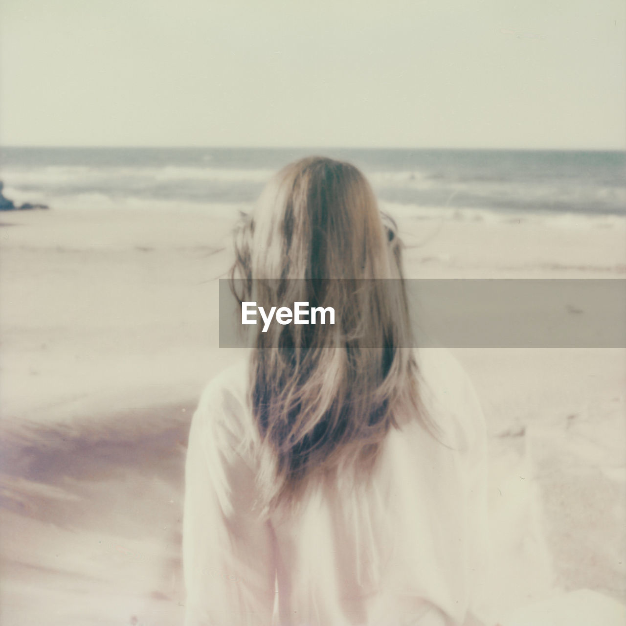 Woman at beach against clear sky