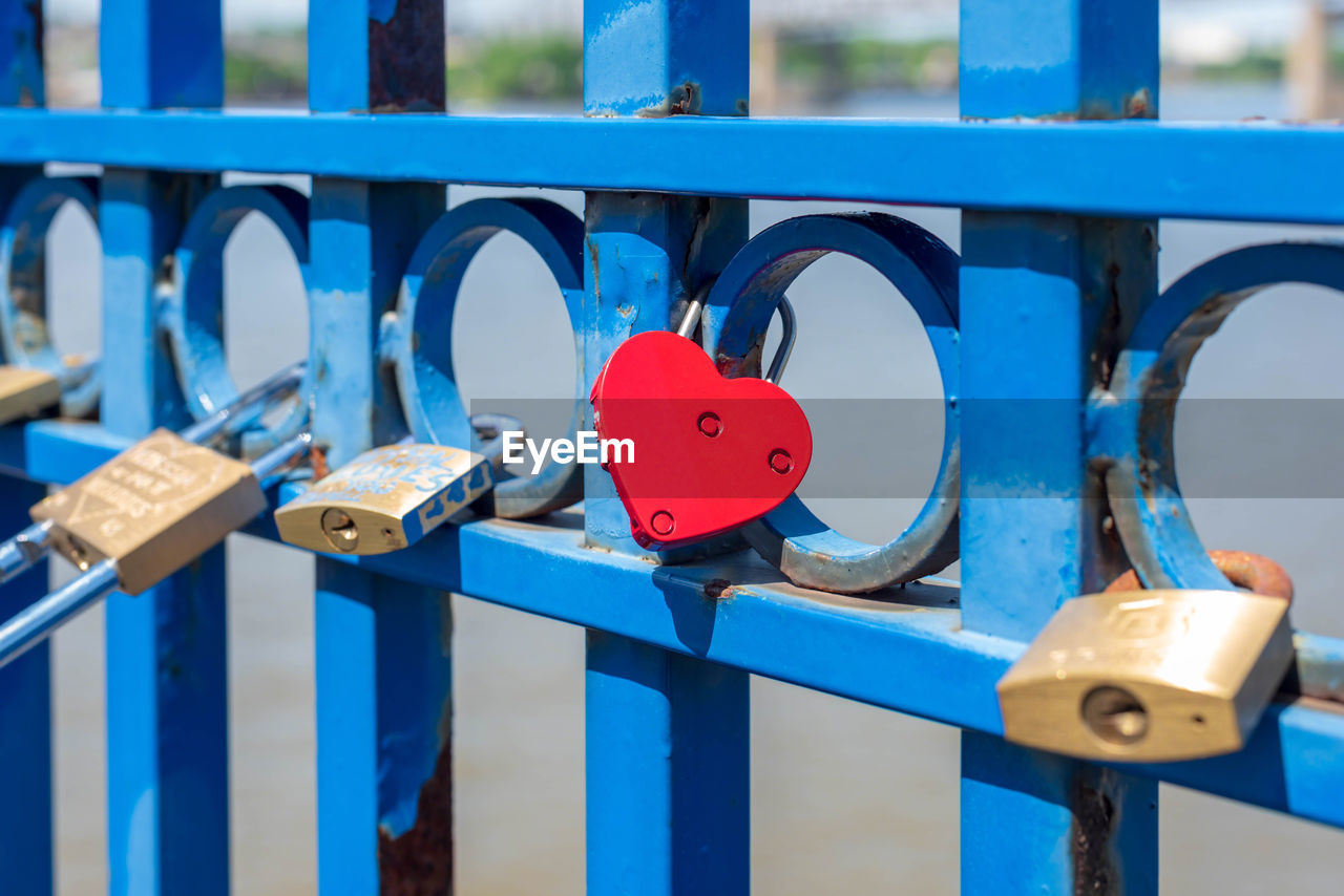 Close-up of padlocks on fence at bridge