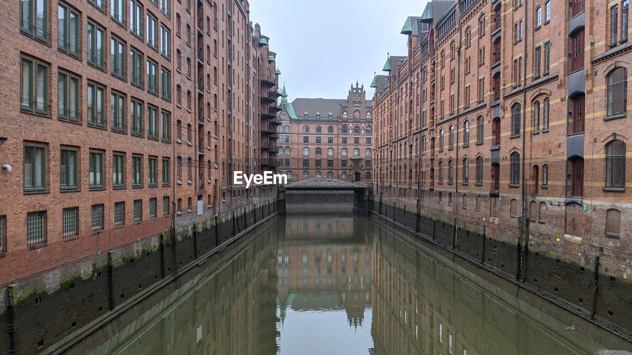 CANAL AMIDST BUILDINGS AGAINST SKY