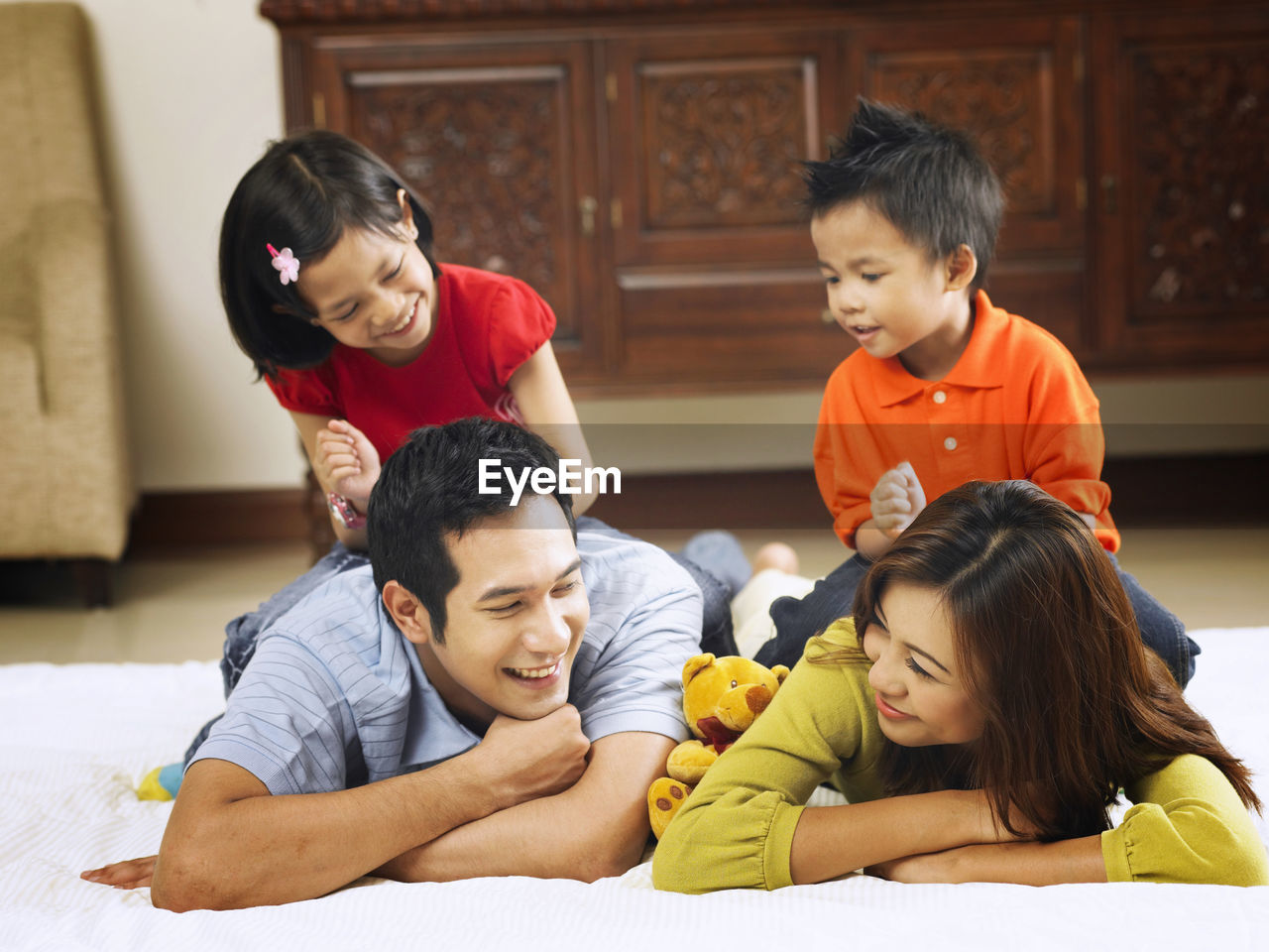 Happy family lying on mattress at home