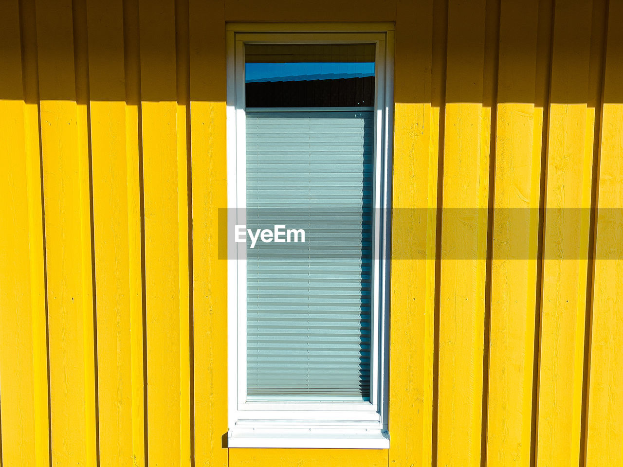Closed window in yellow building