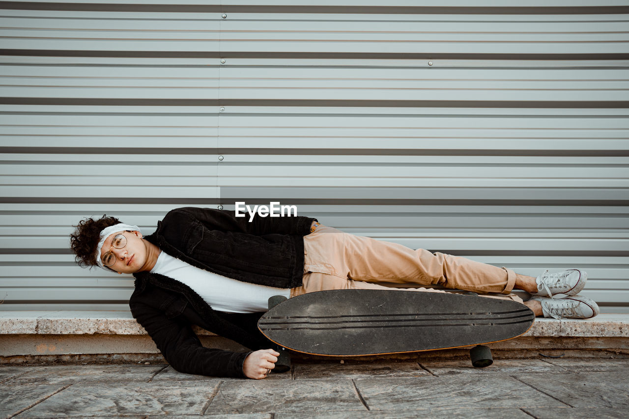 FULL LENGTH OF A MAN SLEEPING ON SHUTTER