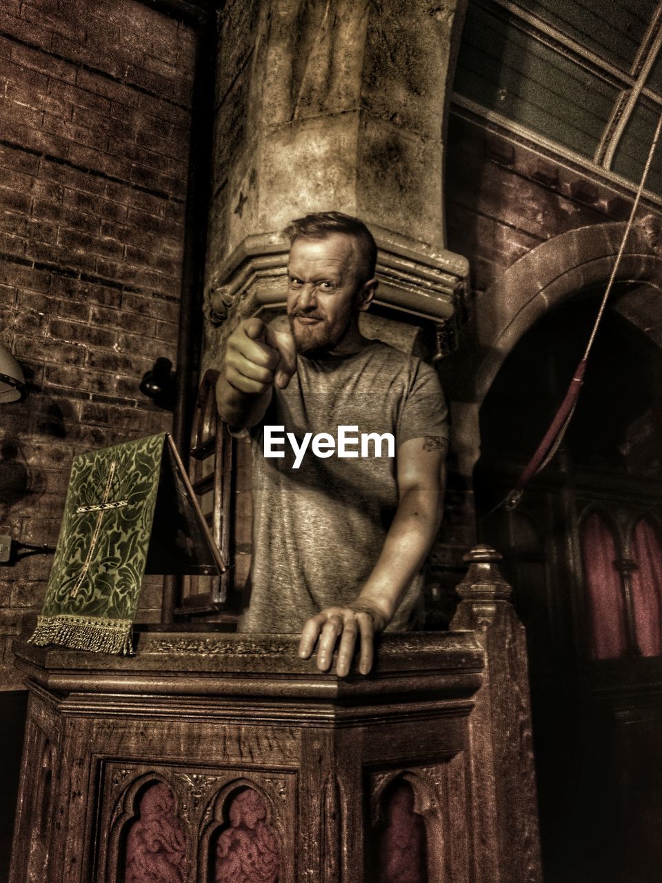 Portrait of man pointing while standing at pulpit in church