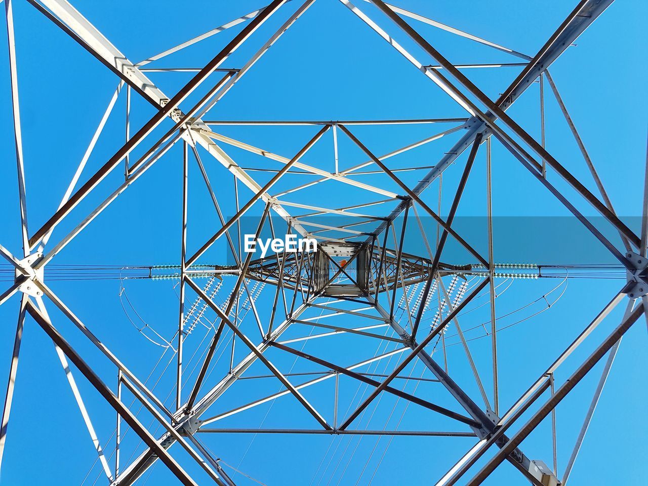LOW ANGLE VIEW OF ELECTRICITY PYLON AGAINST CLEAR BLUE SKY
