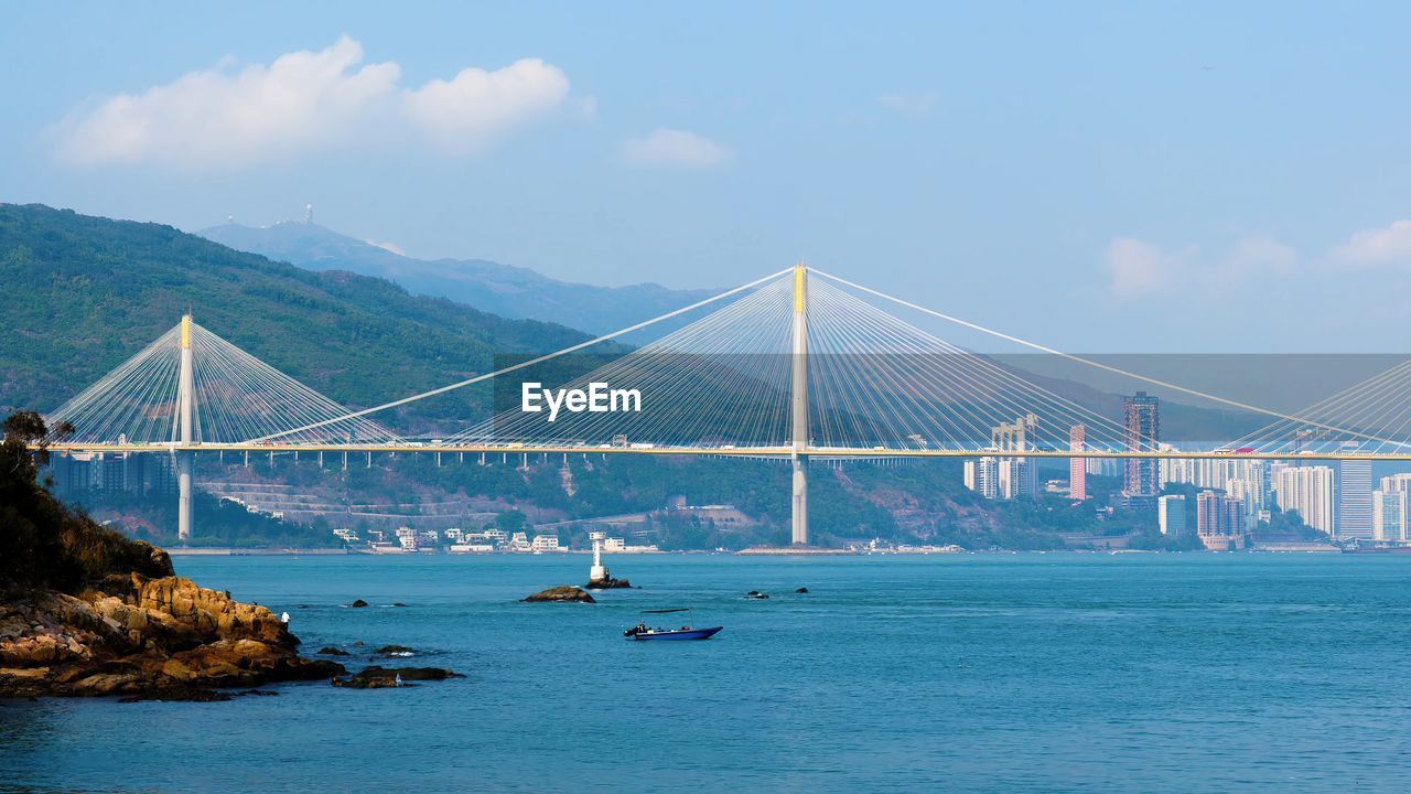 Suspension bridge over sea against sky, hongkong building and landscape