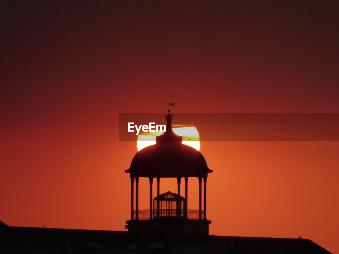 Silhouette tower of building against sky during sunset