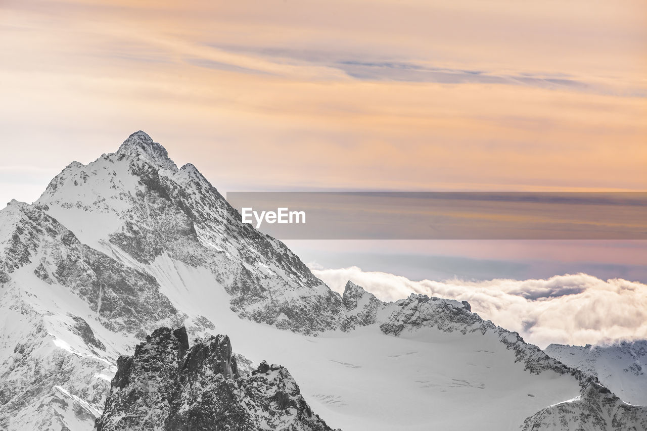 Scenic view of snowcapped mountains against sky during sunset