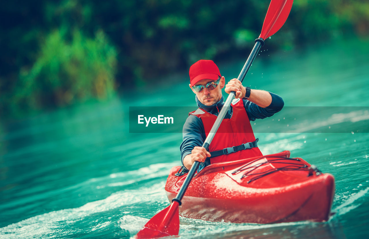 MIDSECTION OF MAN WITH RED UMBRELLA