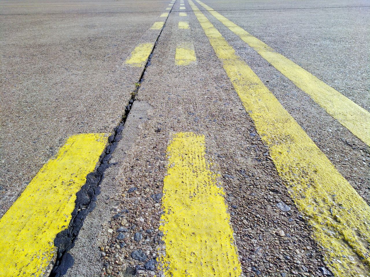 High angle view of yellow arrow symbol on road