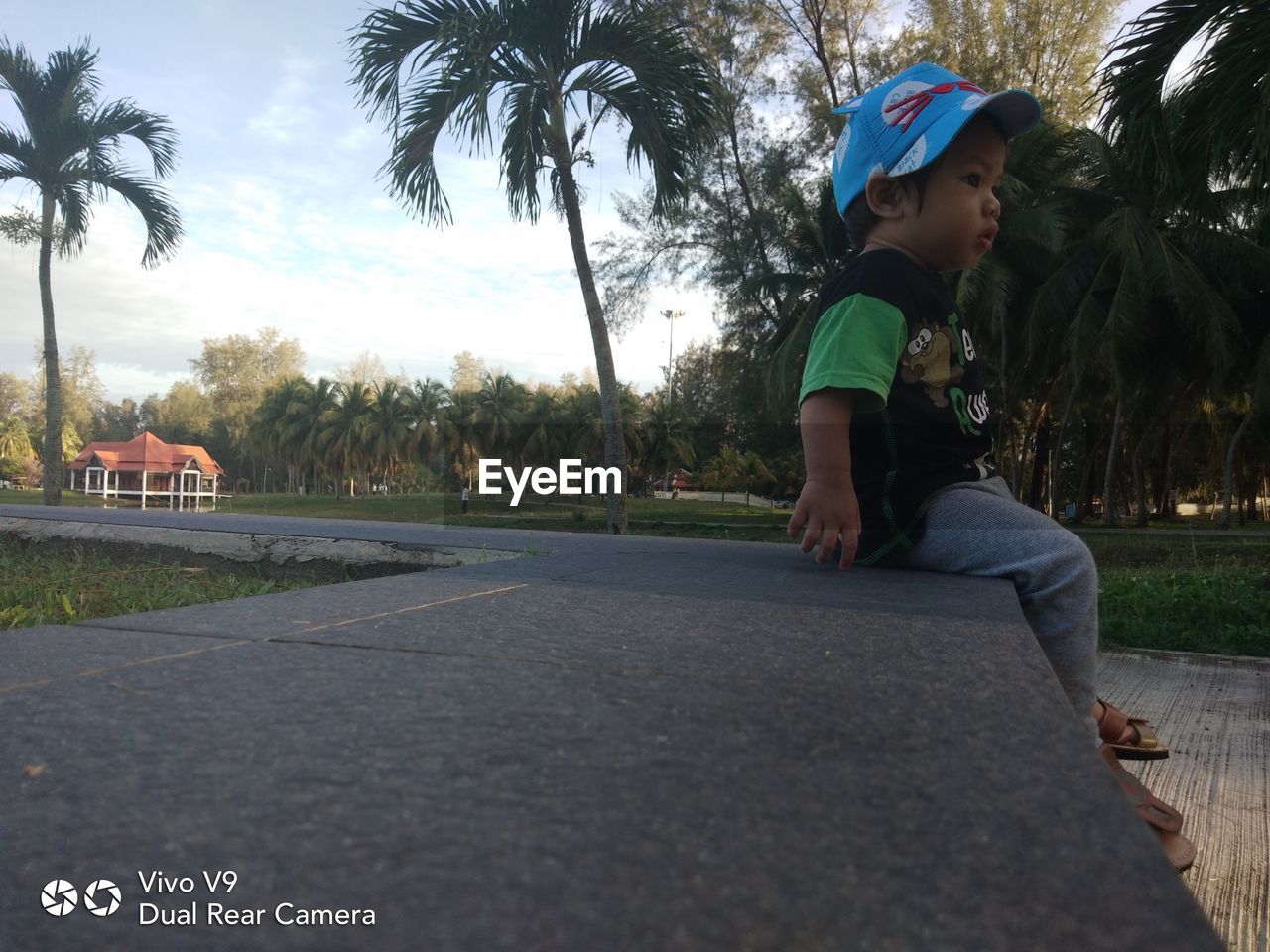 REAR VIEW OF BOY LOOKING AT CAMERA