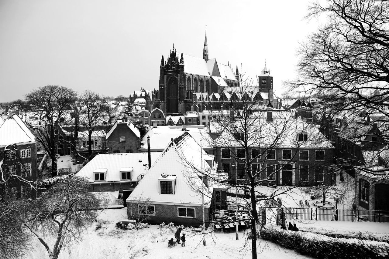 Snow covered buildings against clear sky