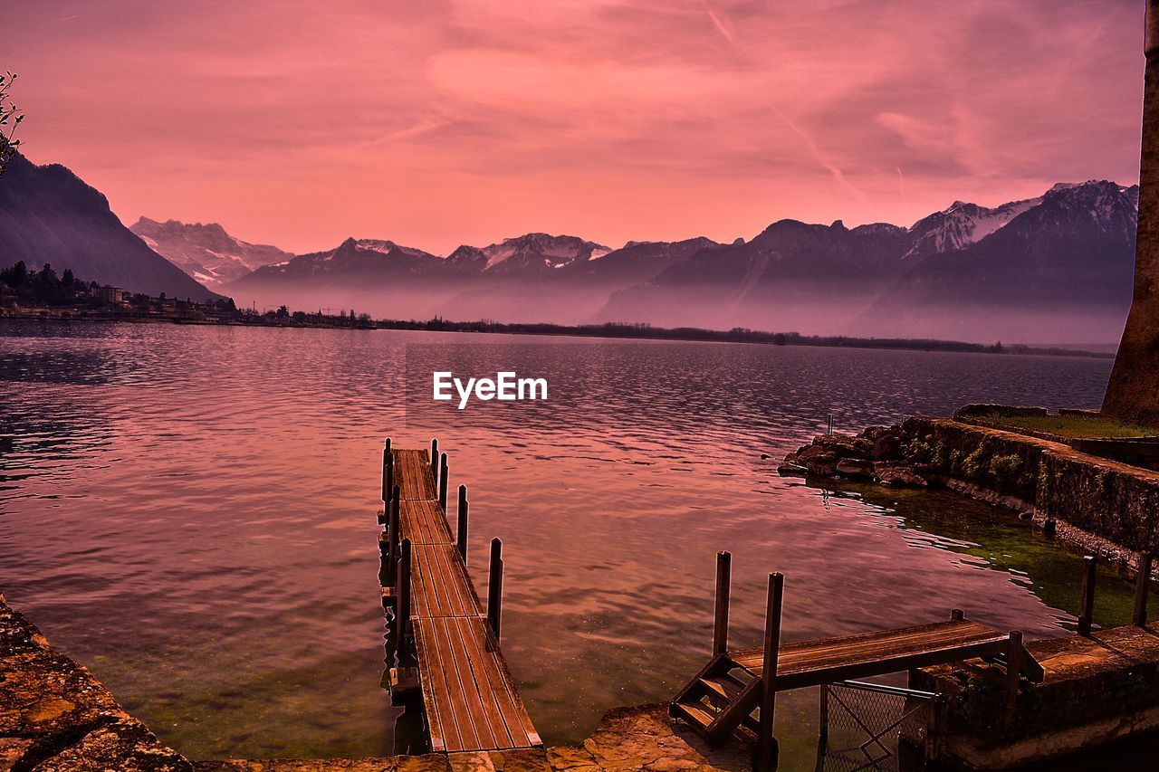 Chateau montreux switzerland wooden posts in lake against sky during sunset
