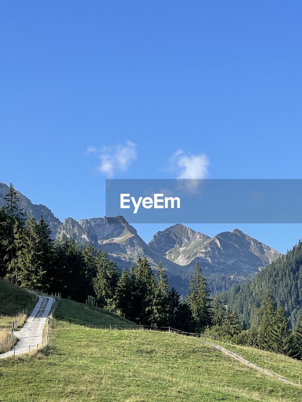 sky, nature, blue, mountain, day, terrain, plant, no people, cliff, low angle view, mountain range, tree, reflection, outdoors, beauty in nature, cloud, rock, architecture, scenics - nature, sunlight, travel, tranquility, travel destinations, environment, land, built structure, landscape