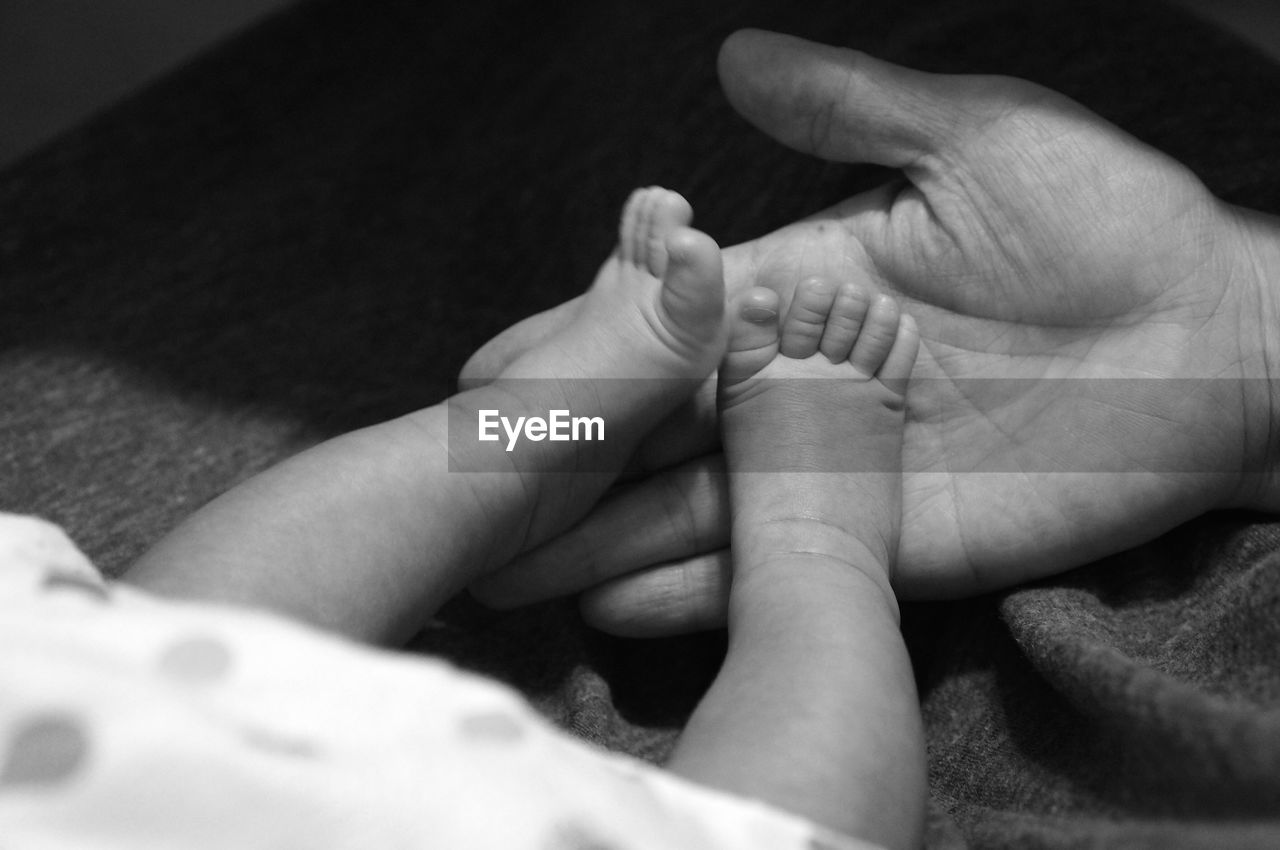 Cropped hand touching feet of baby