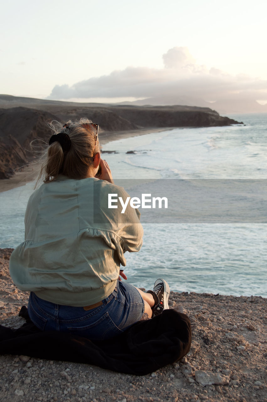 Woman/girl is enyoing the sunset in fuerteventura