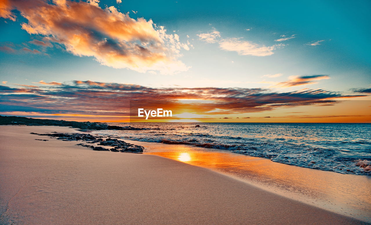 Scenic view of beach against sky during sunset