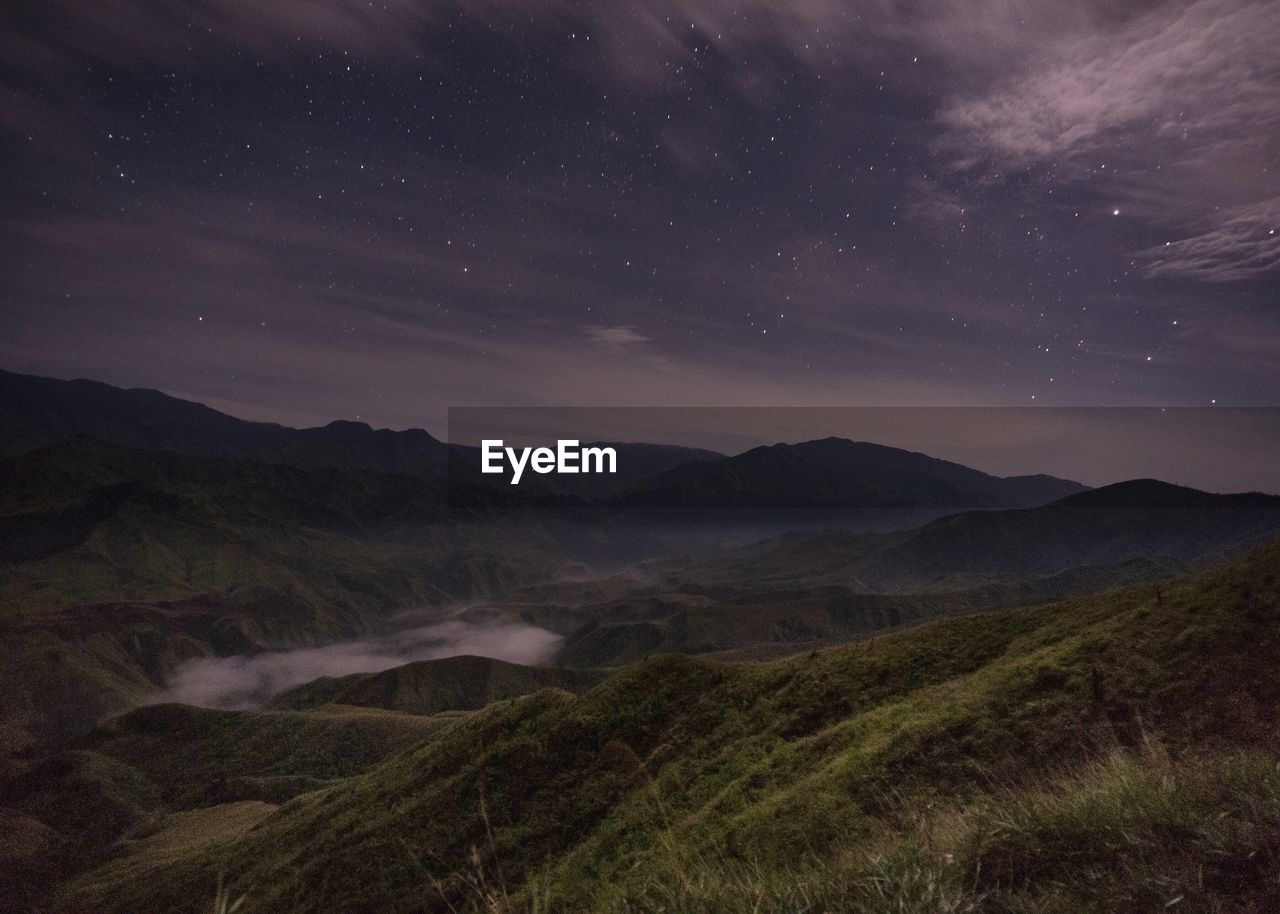 Scenic view of landscape against sky at night