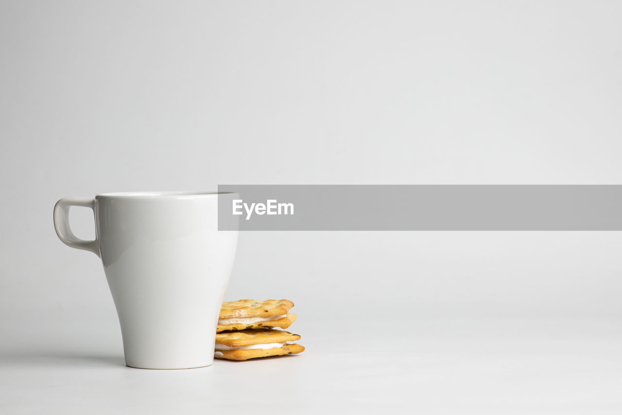 Close-up of coffee cup on table against white background