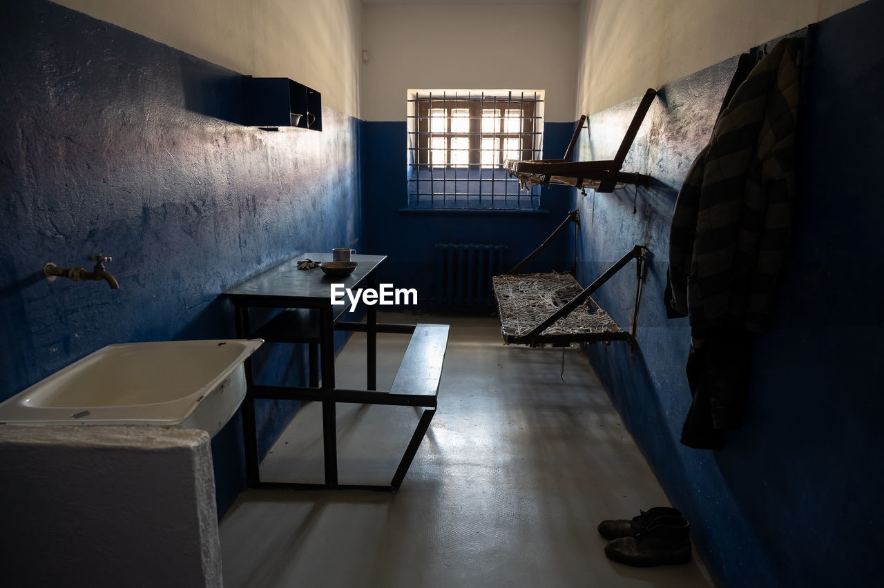 EMPTY CHAIRS AND TABLE AGAINST WALL IN ROOM