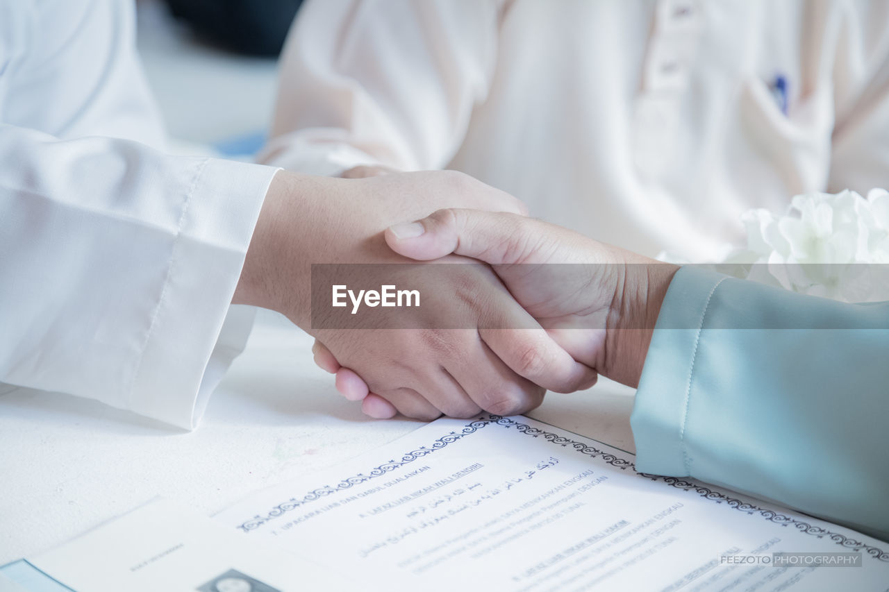 Close-up of people shaking hands on table