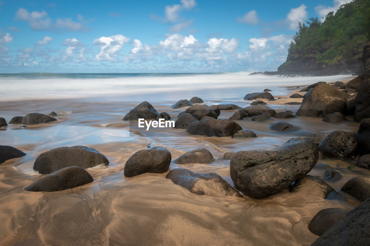 Rocks on beach against sky