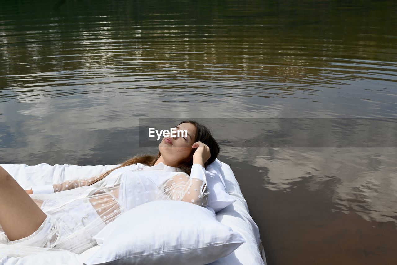 High angle view of woman lying on lake