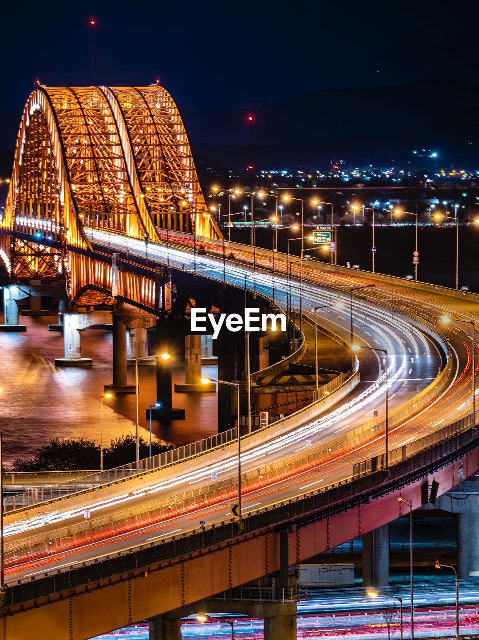 Light trails on bridge in city at night