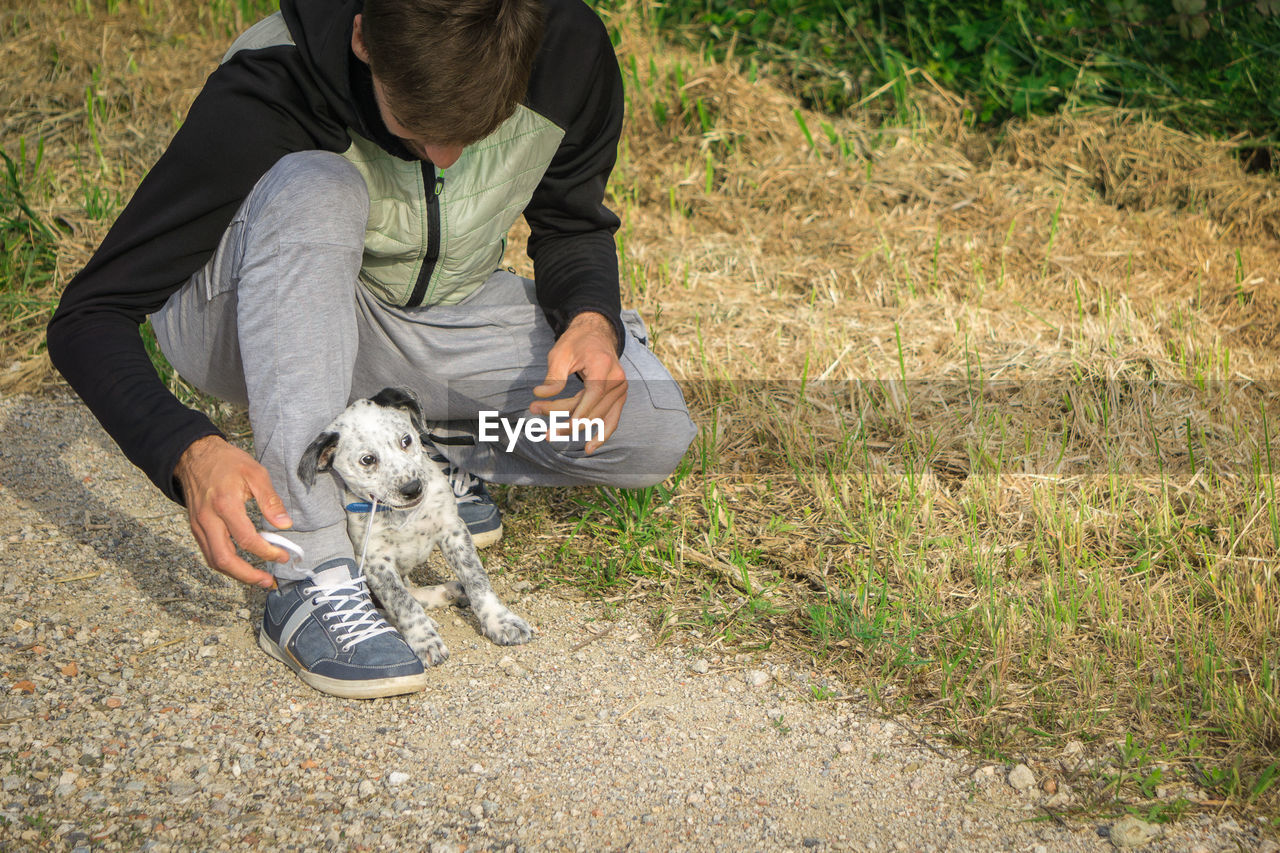 Full length of man playing with puppy