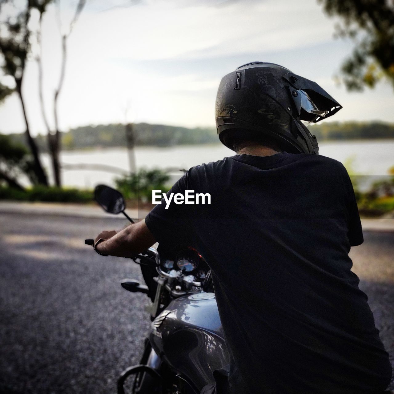 Rear view of man riding motorcycle on road