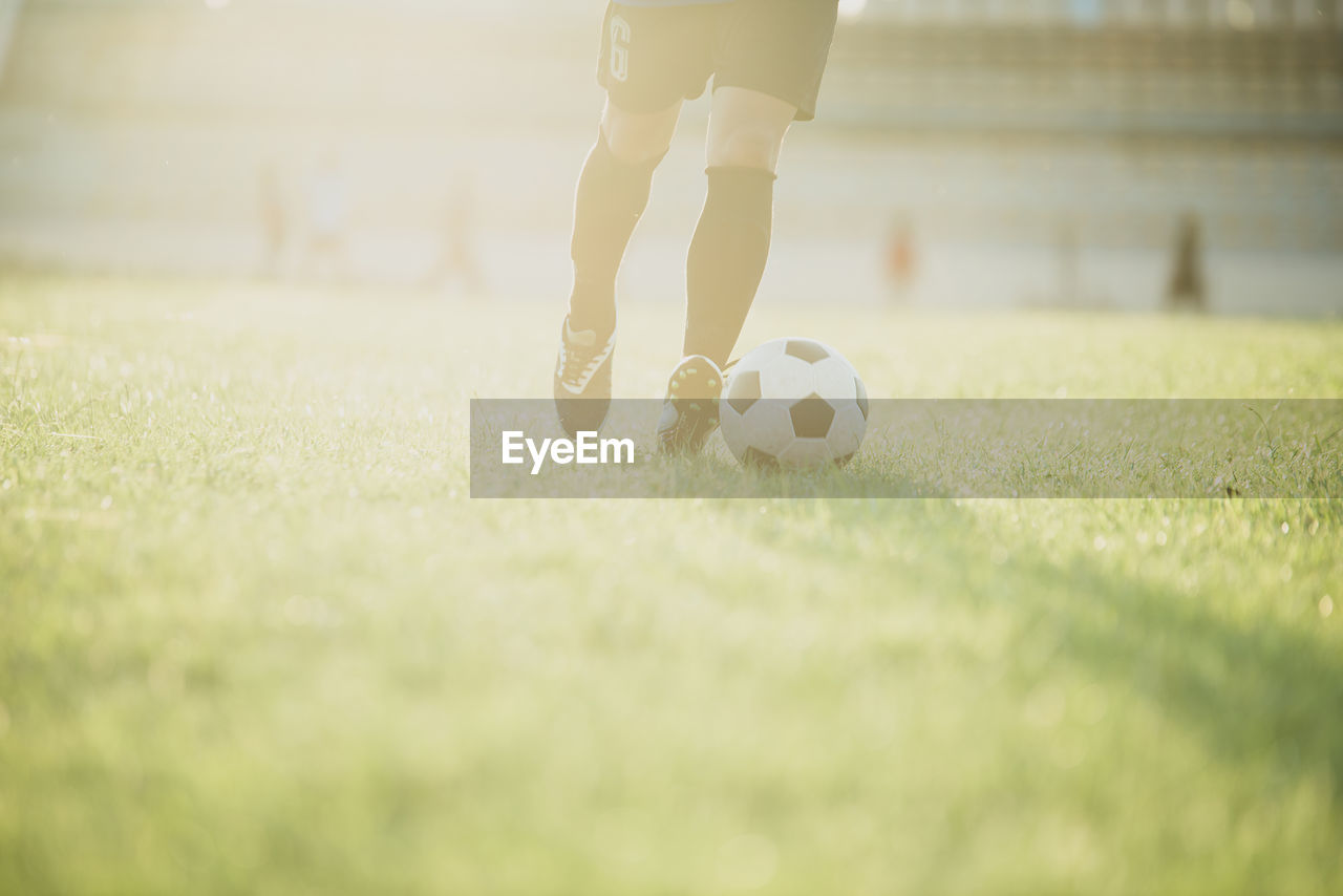 LOW SECTION OF MAN PLAYING SOCCER BALL