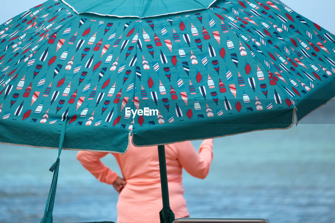 Portrait of woman under beach umbrella