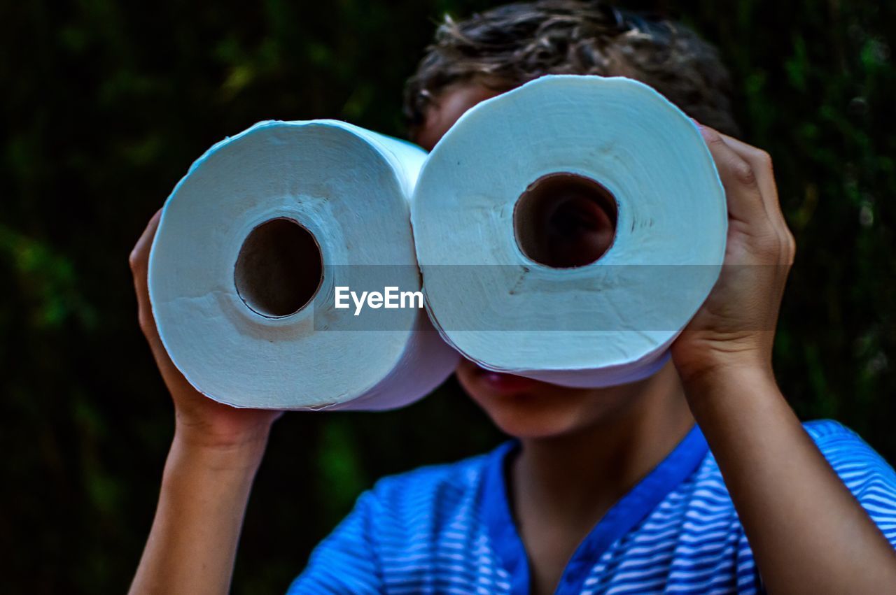 Boy with face covered by toilet papers