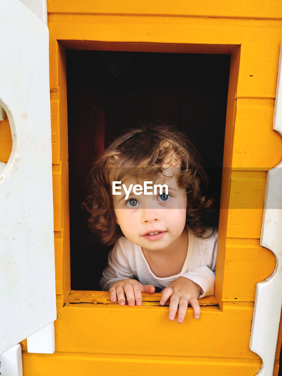 Blue-eyed girl playing in the dollhouse.