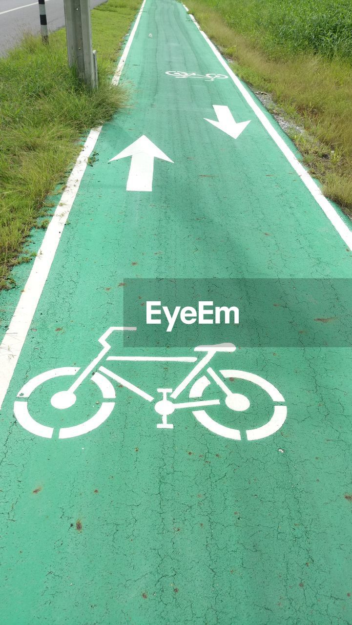 HIGH ANGLE VIEW OF ARROW SYMBOL ON ROAD SIGN