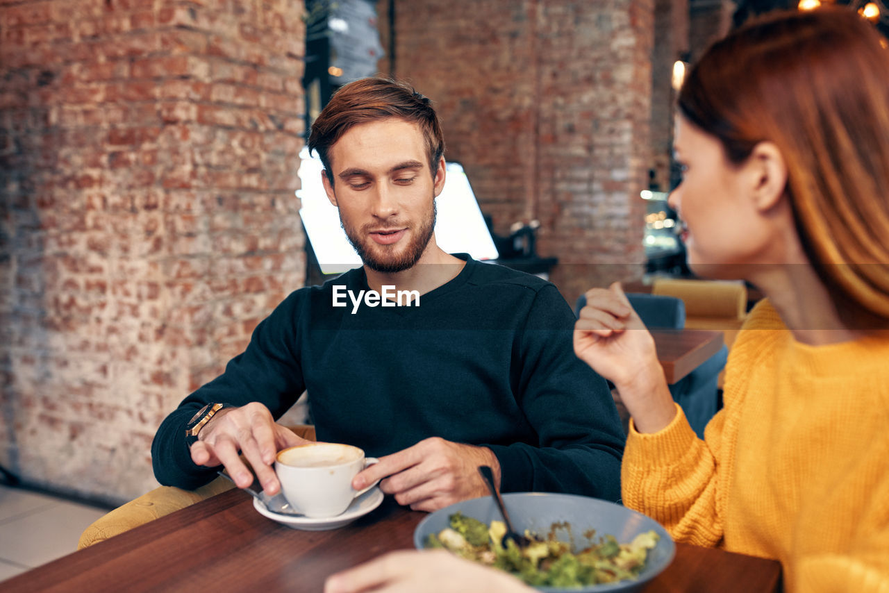 Young couple sitting on table at restaurant