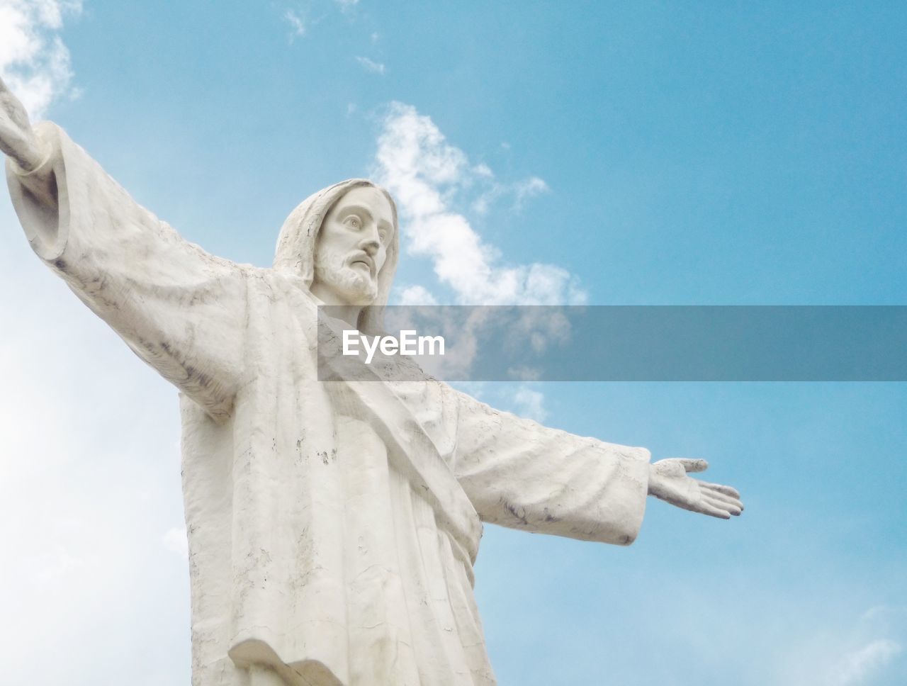 Low angle view of jesus statue against sky