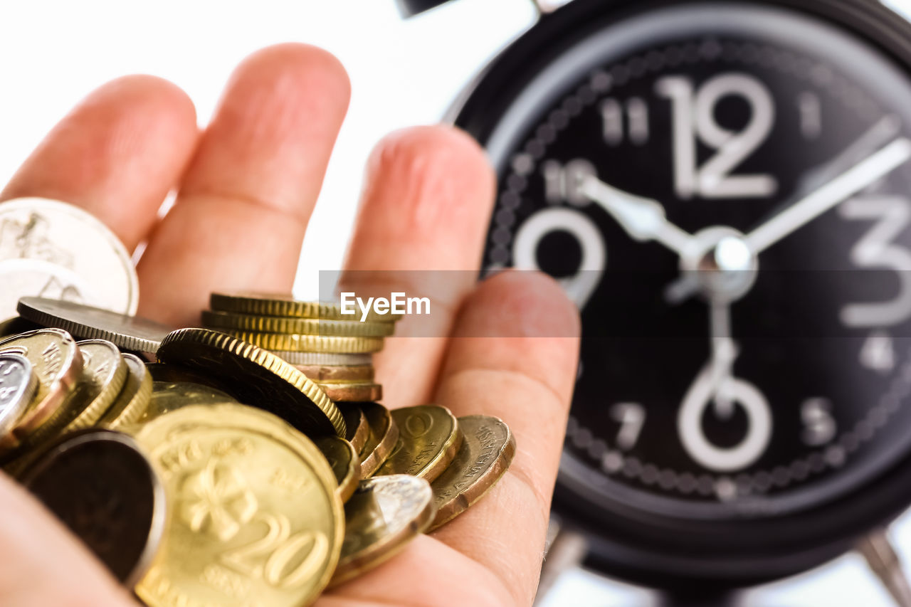 CLOSE-UP OF A HAND HOLDING COIN