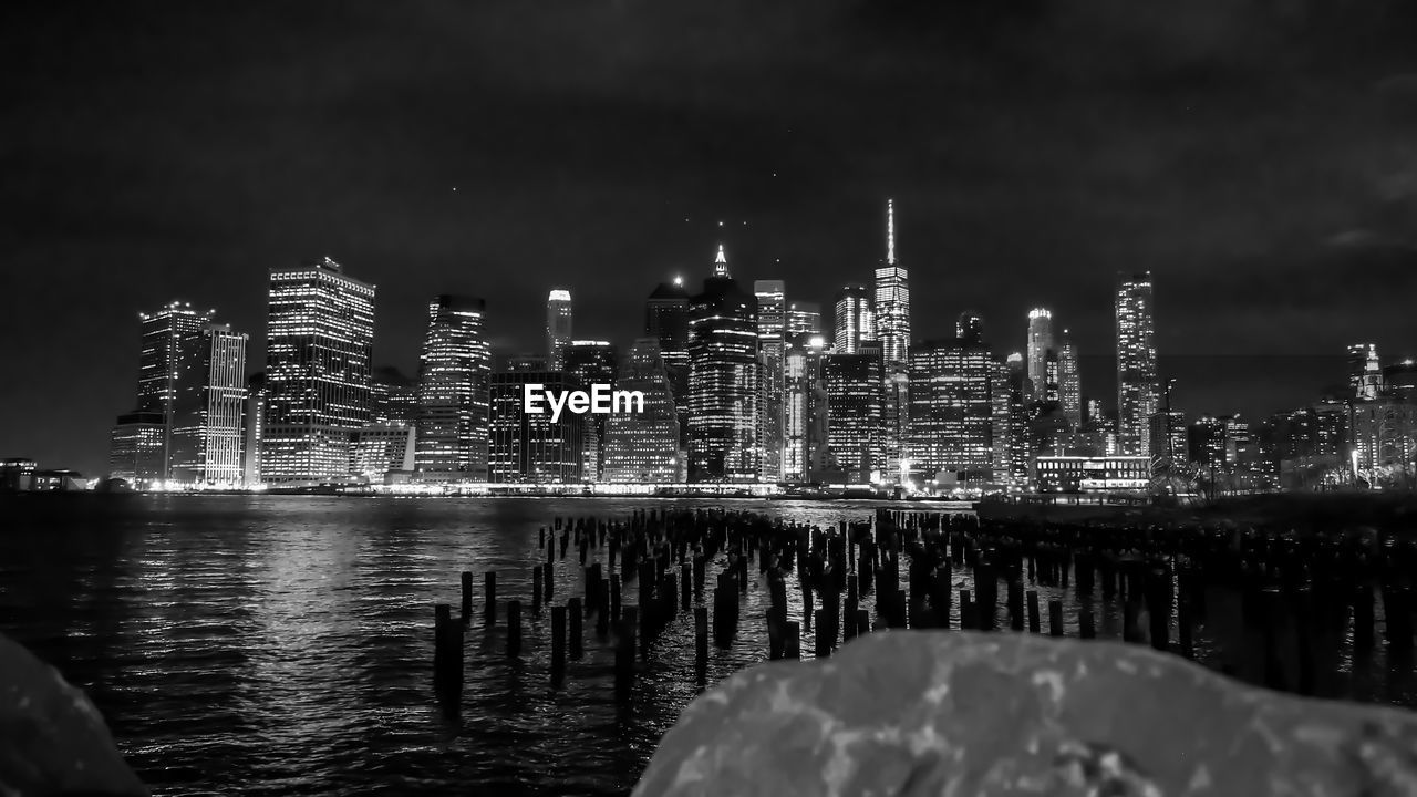 River against illuminated skyscrapers in city at night