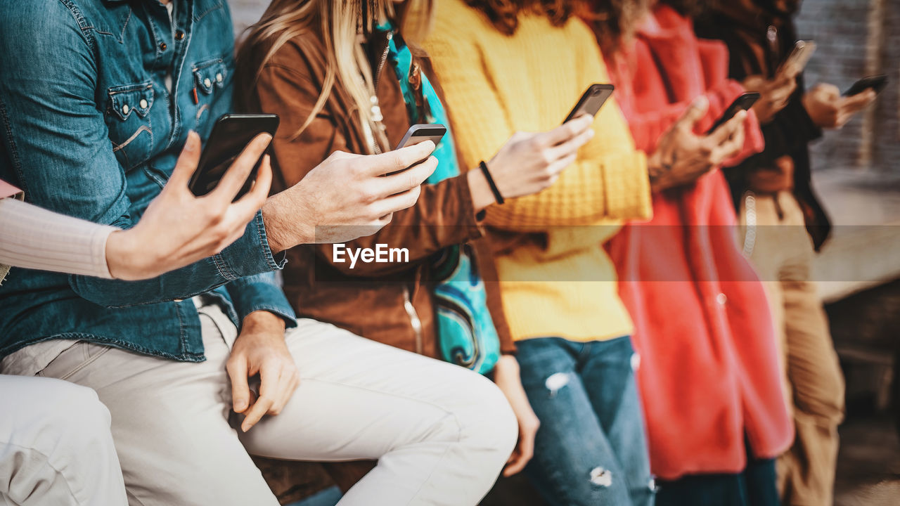 Group of young people using smartphone and social network applications