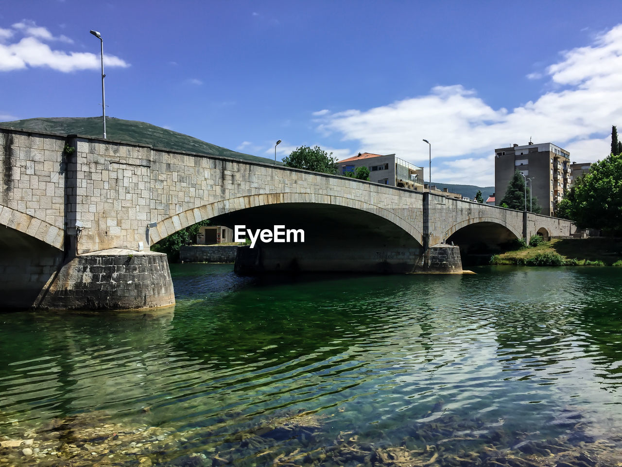 Arch bridge over river against sky